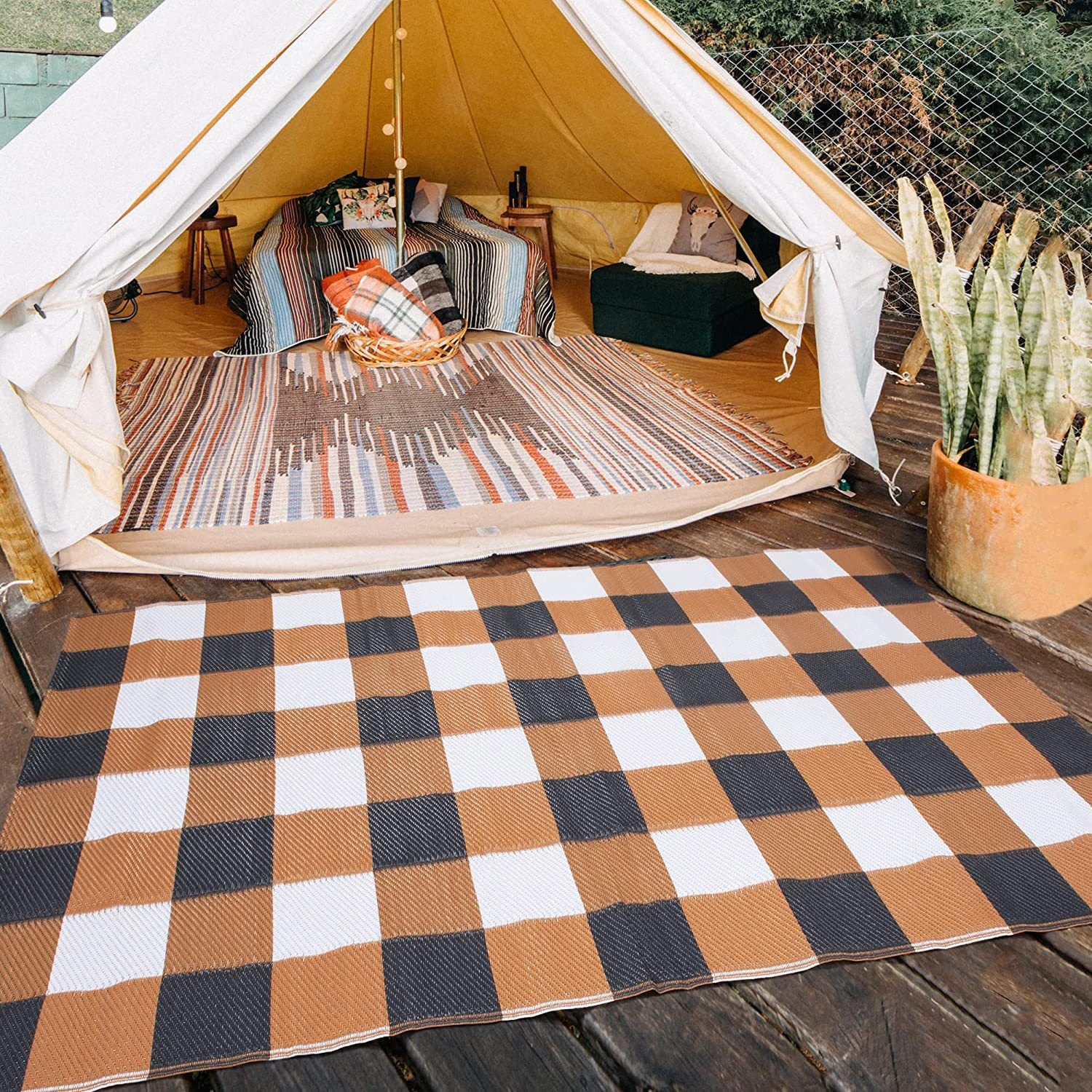 Checked outdoor ground mat laid on a wooden platform at a campsite